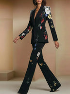 Traje de dos piezas compuesto por blazer y pantalón de un solo botón con estampado floral negro.